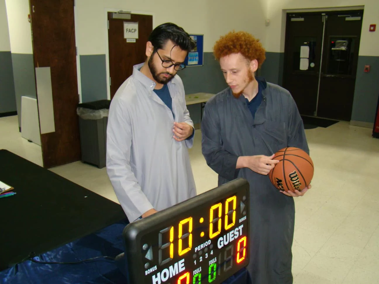 ICC community gathering beside a basketball scoreboard